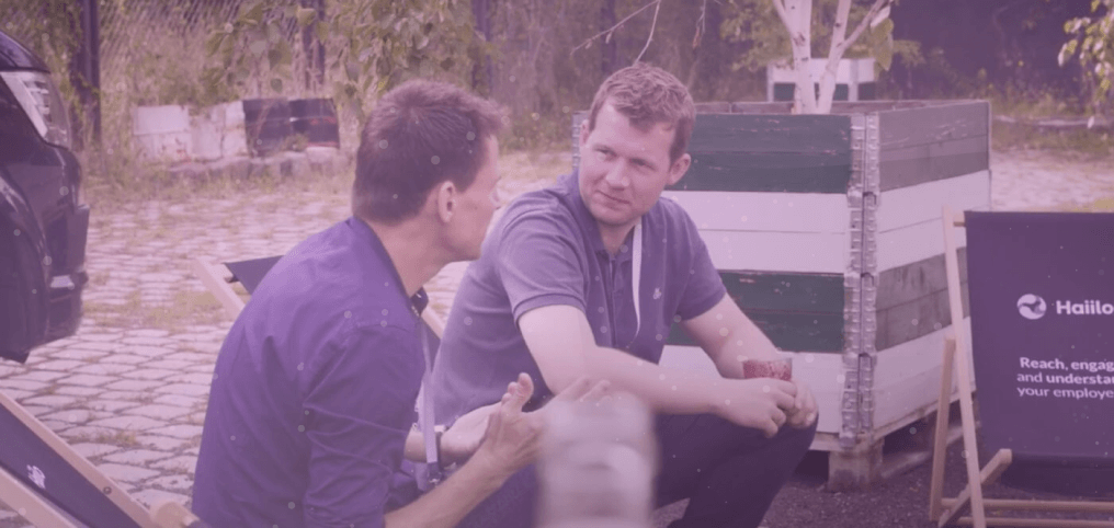 two men sitting outside and talking