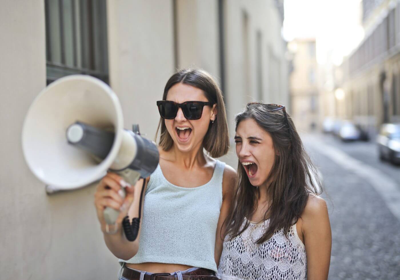 two girls yelling in a megaphone