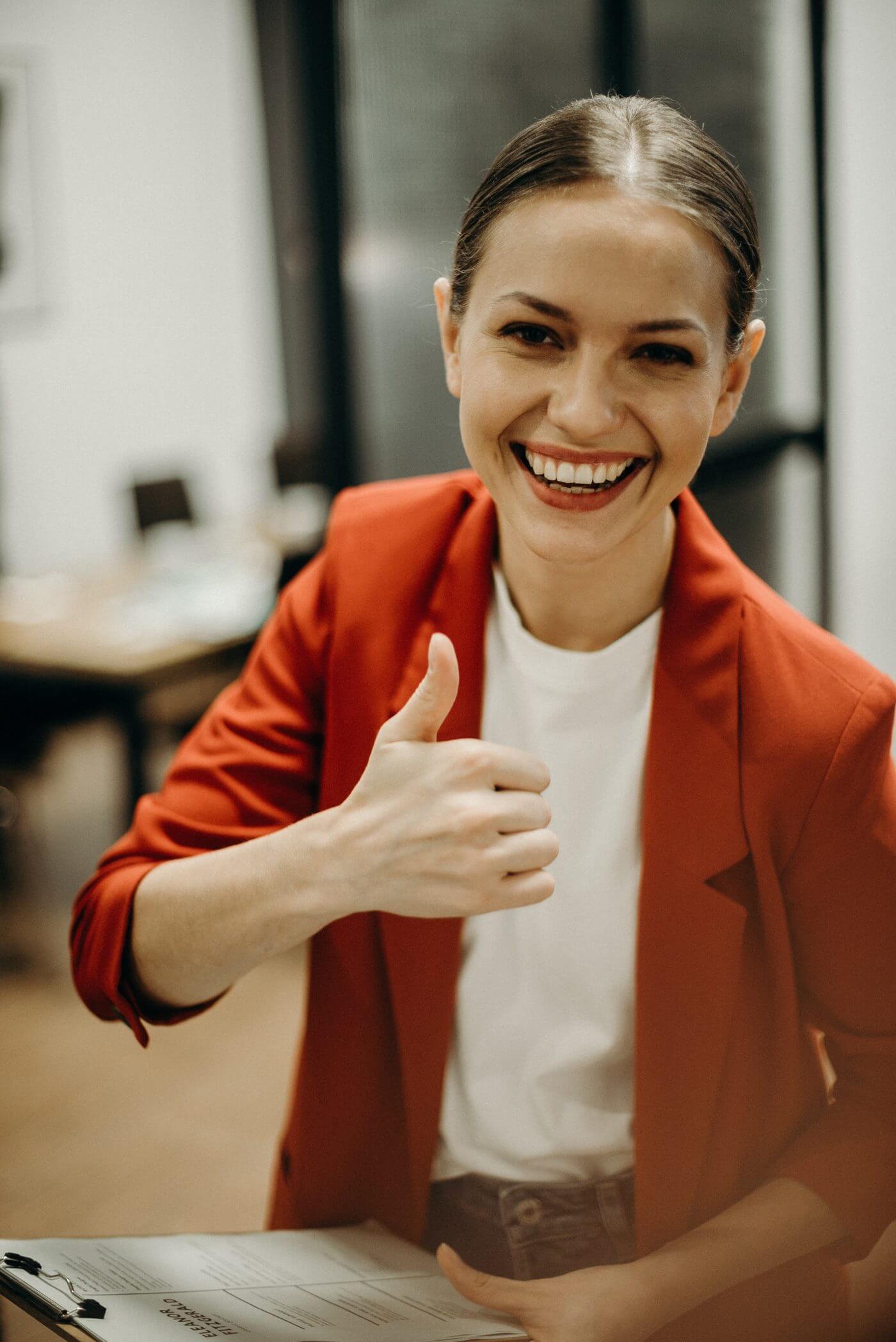 young businesswoman smiling and showing thumbs up