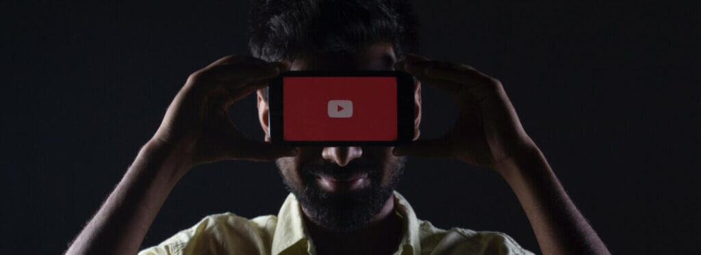 a man holding a phone on his face wit a youtube logo