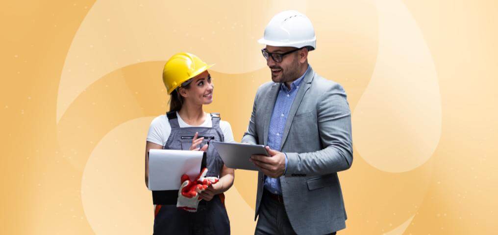 two workers with helmets talking and looking at notes