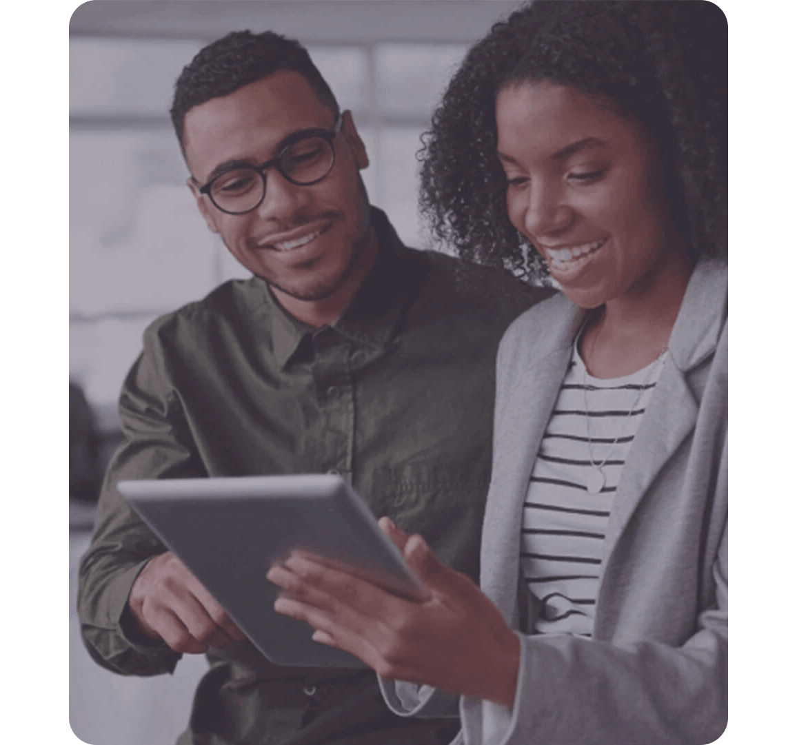 man and woman looking something on tablet and smiling